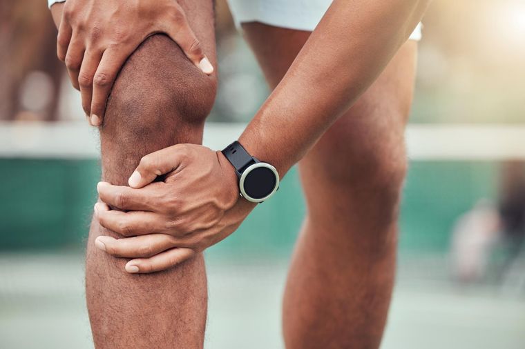 Atleta com dor no joelho durante a prática esportiva